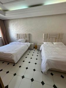 twee bedden naast elkaar in een slaapkamer bij 锦鲤JinLi Central in Casablanca