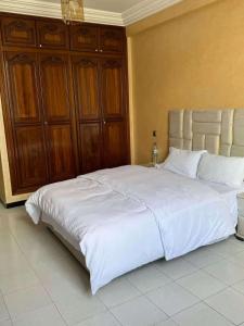een slaapkamer met een groot bed met witte lakens bij 锦鲤JinLi Central in Casablanca