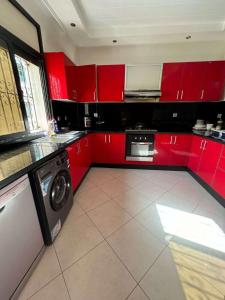 een keuken met rode kasten en een wasmachine bij 锦鲤JinLi Central in Casablanca +7 foto's