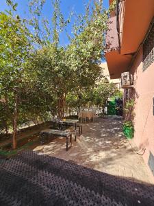 a group of benches in a courtyard with trees at Marrakech plus in Marrakesh