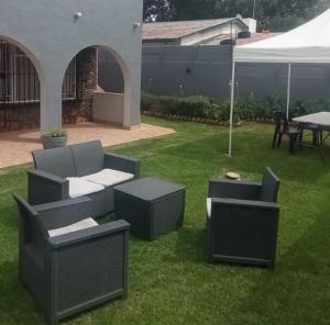 a group of chairs and tables in a yard at Lifegate Guesthouse in Johannesburg +27 photos
