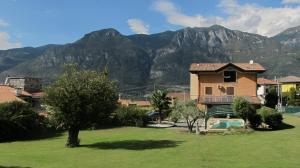 une maison dans un champ avec des montagnes en arrière-plan dans l'établissement Casa Guglielmo, à Pisogne