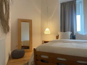 een slaapkamer met een groot bed en een spiegel bij Halluin Marthe Nollet in Halluin