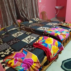 a group of four beds sitting in a room at ASA Homestay in Mādangeri