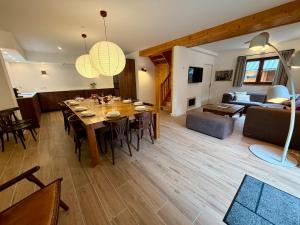 een eetkamer en woonkamer met een tafel en stoelen bij Chalet Les Ecrins in Vénosc