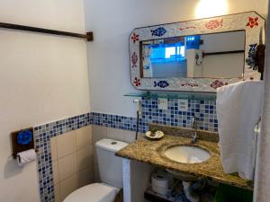 Casa Verde Apart Apartamentos com cozinha في برايا دو فورتي: حمام مع حوض ومرحاض ومرآة +99 صورة