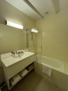 ein Badezimmer mit Waschbecken und Badewanne in der Unterkunft Logis Hôtel la Vallée de l'Arc in Trets