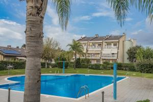 a swimming pool with a palm tree in front of a building at La casa di Plinio in Infernetto