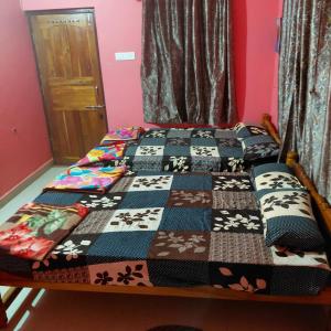 a bed with a quilt on it in a room at ASA Homestay in Mādangeri
