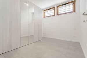 an empty bathroom with white walls and a window at La casa di Plinio in Infernetto