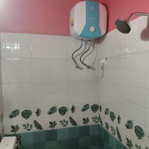 a bathroom with a hair dryer on the wall at ASA Homestay in Mādangeri