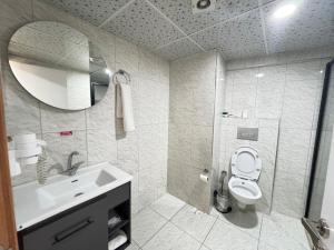 un bagno con lavandino, WC e specchio di ergene park hotel 