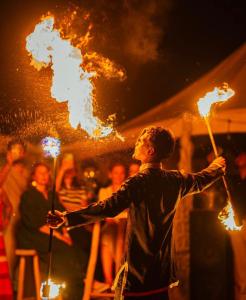 Een man houdt een stok met vuur vast. bij Agafay Private evening camel ride sunset dinner show private experience in Marrakesh