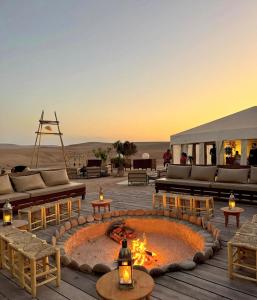 een terras met een vuurkuil midden in de woestijn bij Agafay Private evening camel ride sunset dinner show private experience in Marrakesh