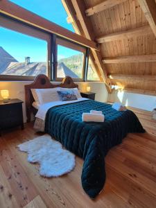 a large bed in a room with large windows at NEW Locanda da Raimondo - das Knarren der Zeit in Tarvisio