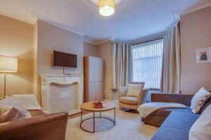 a living room with a couch and chairs and a tv at Manor Castle View 3BR House Free Parking & Garden in Victoria