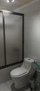 a bathroom with a white toilet and a glass table at A pasos de Ruta Cinco y Universidad in Talca