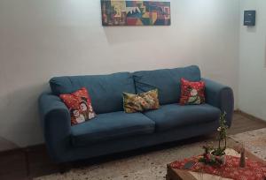 a blue couch with pillows on it in a living room at A pasos de Ruta Cinco y Universidad in Talca