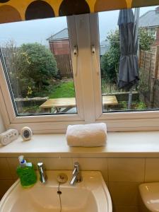 a bathroom sink with a window above a sink at Manor Castle View 3BR House Free Parking & Garden in Victoria +84 photos