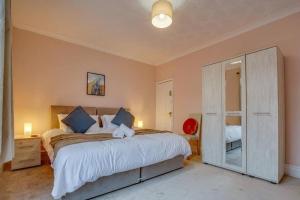 a bedroom with a large bed and a mirror at Manor Castle View 3BR House Free Parking & Garden in Victoria