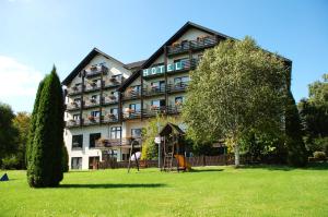 un bâtiment d'hôtel avec une aire de jeux en face dans l'établissement Wohlfühlhotel DER JÄGERHOF, à Willebadessen