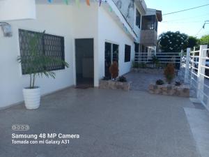 a white house with a courtyard with a potted plant at Hotel H&H in Cartagena de Indias +16 photos