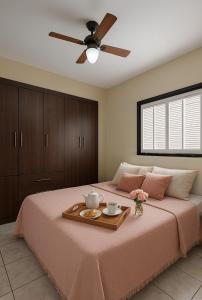 une chambre avec un lit avec un plateau de nourriture dessus dans l'établissement Casa Lopes temporada Ubatuba, à Ubatuba 31 autres photos