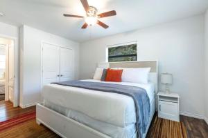 une chambre blanche avec un lit et un ventilateur de plafond dans l'établissement Stadium Oasis, à Arlington