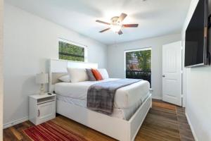 een witte slaapkamer met een bed en een plafondventilator bij Stadium Oasis in Arlington +24 foto's