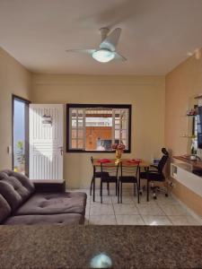 un salon avec un canapé et une table avec des chaises dans l'établissement Casa Lopes temporada Ubatuba, à Ubatuba