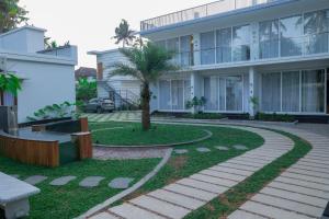 een gebouw met een palmboom ervoor bij Palm Wave Beach Resort in Cochin