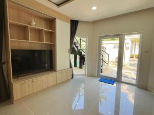 a living room with a flat screen tv on a entertainment center at 3BR Pool Villa Beach Access Patumnak Hill in Pattaya South