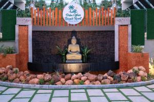 een standbeeld van een Boeddha voor een fontein bij Palm Wave Beach Resort in Cochin
