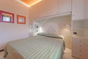 een kleine slaapkamer met een bed en witte kasten bij Il Porto 19 - Goelba in Porto Azzurro