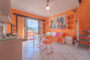 een kamer met oranje muren en een keuken met een tafel bij Il Porto 19 - Goelba in Porto Azzurro