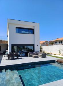 a house with a swimming pool in front of a house at Casa Terra das Vinhas in Esposende