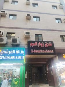 Un edificio con letreros en el costado. en Zwar Alharam Makkah Hotel, en La Meca
