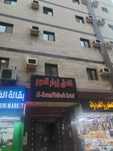 Un edificio con letreros en el frente. en Zwar Alharam Makkah Hotel, en La Meca