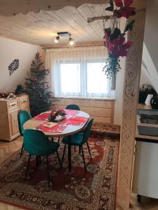a kitchen with a table and chairs and a christmas tree at Apartamenty HAWOK in Groń