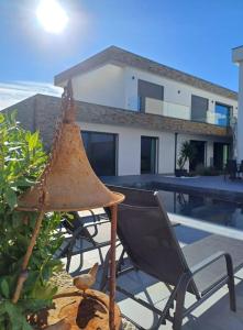 a patio with a chair and a house at Casa Terra das Vinhas in Esposende