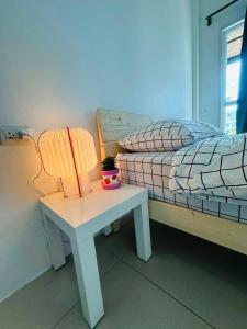 een slaapkamer met een bed en een tafel met een lamp bij HulaFling Homestay in Ban Bo Han