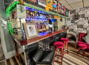 - un bar avec deux tabourets et un comptoir avec des boissons dans l'établissement Rossall House , For Families & Couples, à Blackpool 82 autres photos