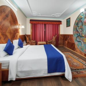 une chambre avec un grand lit avec des oreillers bleus dans l'établissement 4Everstay Grand Luxury Sambhala Premium Rooms Free Parking & Wifi !!! Top Rated & Best Selling Hotel In Manali, à Manali