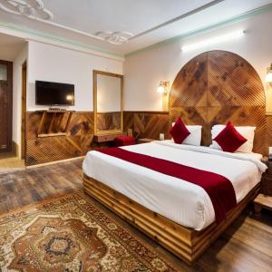 une chambre d'hôtel avec un grand lit et une télévision à écran plat dans l'établissement 4Everstay Grand Luxury Sambhala Premium Rooms Free Parking & Wifi !!! Top Rated & Best Selling Hotel In Manali, à Manali