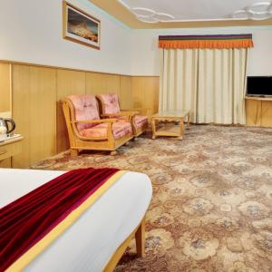 une chambre d'hôtel avec un lit et un canapé dans l'établissement 4Everstay Grand Luxury Sambhala Premium Rooms Free Parking & Wifi !!! Top Rated & Best Selling Hotel In Manali, à Manali