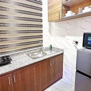 uma cozinha com pia e geladeira em Deluxe One Bedroom Apartment em Ikeja