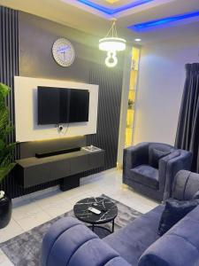 uma sala de estar com um sofá e uma TV em Deluxe One Bedroom Apartment em Ikeja