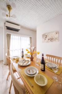 tavolo da pranzo con piatti e bottiglie di vino di Matsumoto Inn a Matsumoto