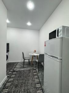 a kitchen with a refrigerator and a table with chairs at Apartament ultra-central in Edineţ