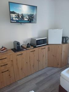 een keuken met houten kasten en een tv aan de muur bij Haus Piller in Bad Hofgastein +83 foto's